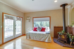 Un dormitorio con cama, chimenea y vistas al exterior.