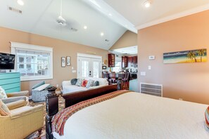 A spacious bedroom with a large bed, a sitting area with a sofa and chairs, a kitchen area, and a dining table. - Heart of Historic Chickamauga! Chic Studio w/ Pool (Chickamauga)
