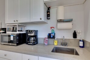 A kitchen with a microwave, coffee maker, sink, and various cleaning supplies. - 4 Mi to Old Pasadena: Walkable Studio (Alhambra)