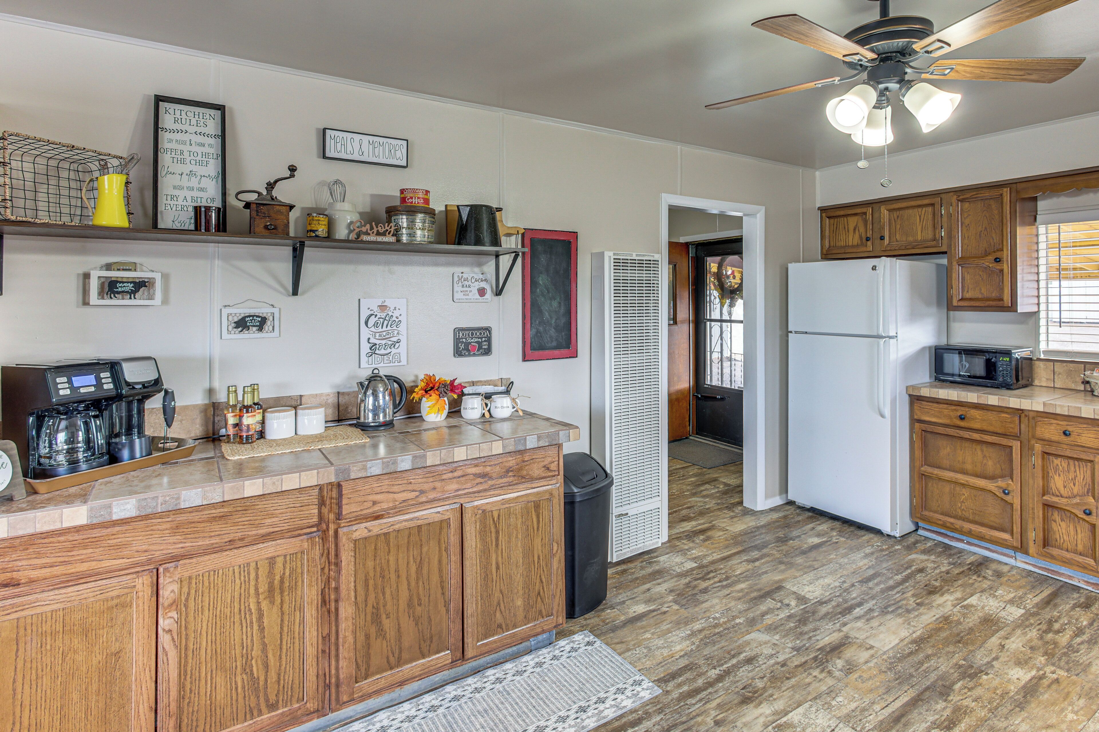 A kitchen with wooden cabinets, a coffee maker, and various kitchen items on the counter.