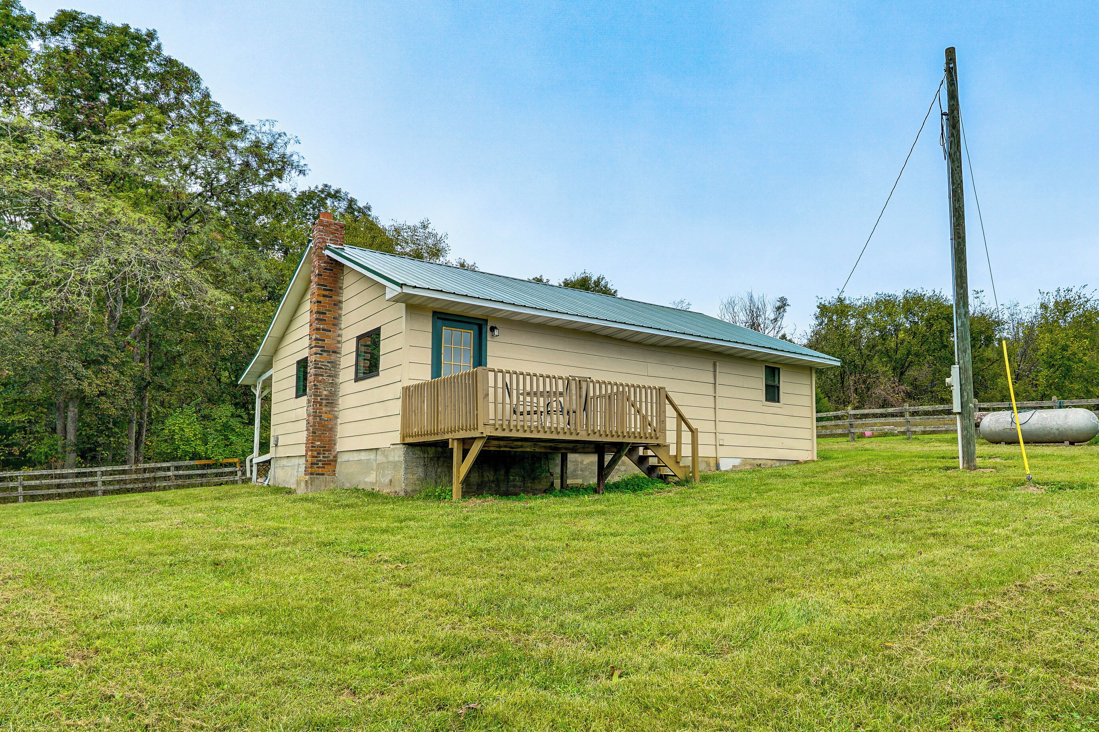 A single-story house with a wooden deck and a metal roof.