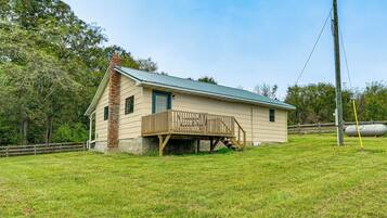 A single-story house with a wooden deck and a metal roof.