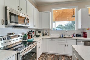 A modern kitchen with white cabinets, stainless steel appliances, a wooden ceiling, and a large window. - Farm Animals On-site: Needville Ranch Getaway! (Needville)