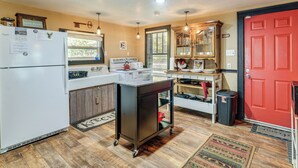 A compact kitchen with a refrigerator, stove, and a small cart. - Hunters/floaters Welcome! Creekside Missouri Cabin (Annapolis)
