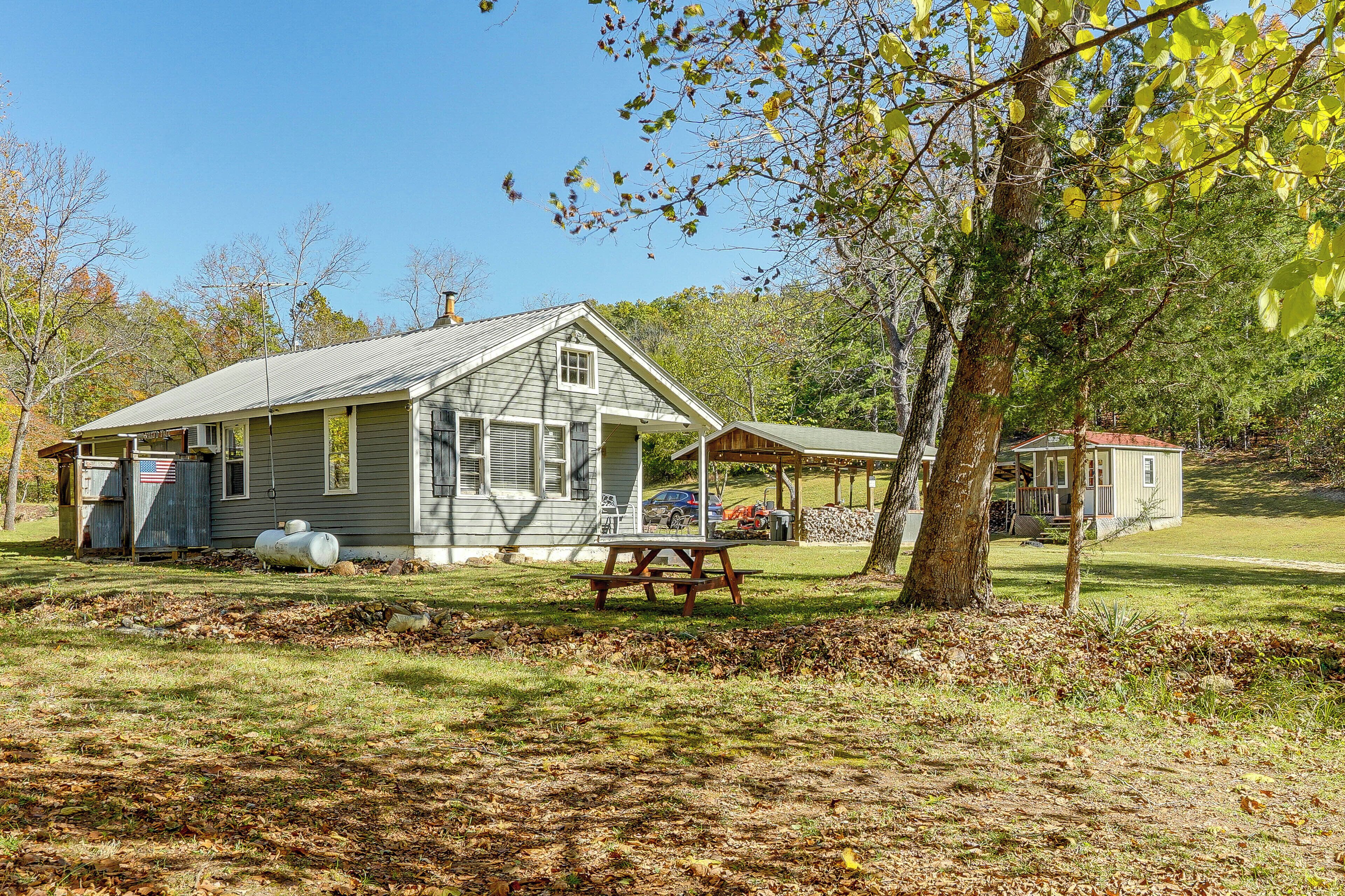 A small, single-story house with a porch and a picnic table in front.