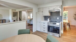 A modern kitchen with white cabinets, a black tiled backsplash, and a built-in oven. - 19 Mi to Kansas City: Group Retreat w/ Game Room! (Blue Springs)