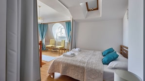 A bedroom with a bed, a chair, a table, and a window. - Apartamenty Świnoujście - Trzy Korony (Świnoujście)