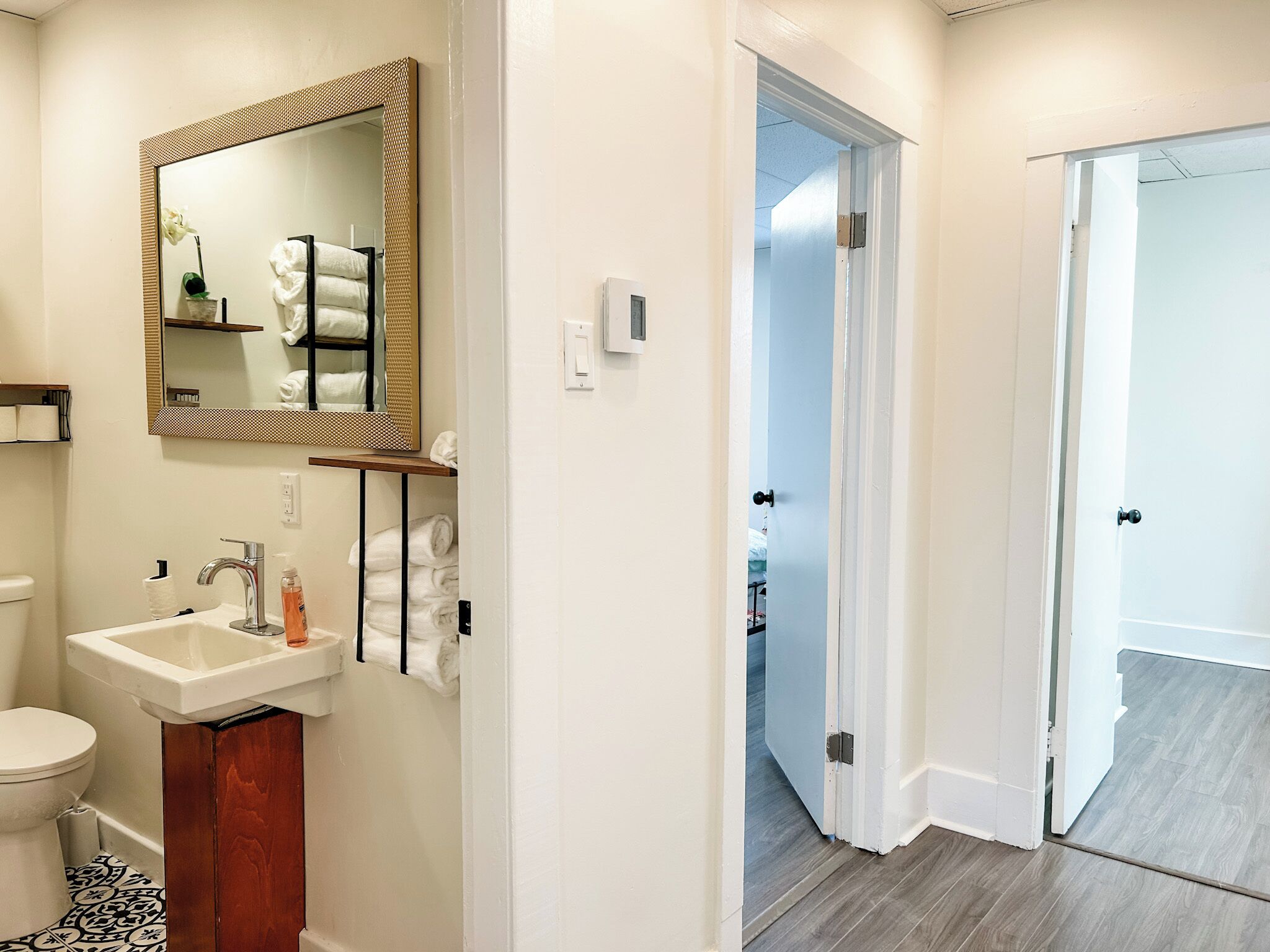 A bathroom with a sink, mirror, and toilet.