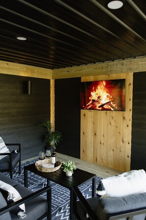 Ein gemütlicher Innenbereich mit Kamin, einem Tisch mit Getränken und einer Couch.