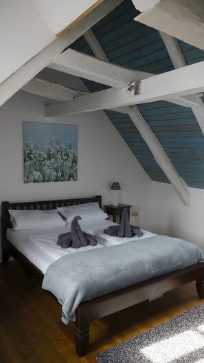 Une chambre à coucher avec un lit, une table de chevet, une lampe et un tableau au mur.