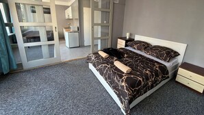 A bedroom with a bed, a nightstand, a dresser, a mirror, and a sliding glass door leading to a bathroom. - Fantastic Inn Warsaw - Kopernika (Warsaw)