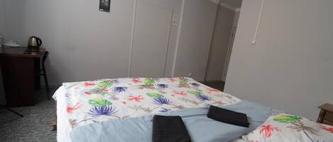 A hotel room with a bed, a desk, and a chair.