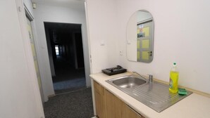 A small kitchenette with a sink, a mirror, and a countertop. - Fantastic Inn Warsaw - Kopernika (Warsaw)