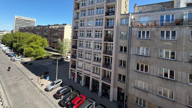 A multi-story residential building with balconies, a parking lot, and a visible storefront. - Fantastic Inn Warsaw - Kopernika (Warsaw)