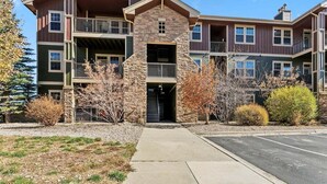A multi-story building with balconies and a stone facade. - Ten Mile B-102 Ground floor 2 bedroom with private patio upscale modern interior (Granby)