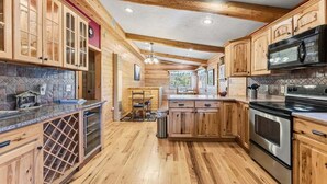 A kitchen with wooden cabinets, a wine rack, and stainless steel appliances. - 279 Shorewood Dr Grand Lake cabin getaway 3 bedroom, private HT, close to town (Grand Lake)