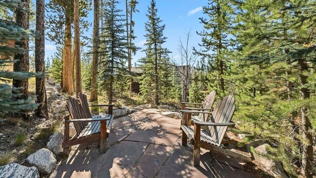 A wooden deck with Adirondack chairs in a forested area. - 279 Shorewood Dr Grand Lake cabin getaway 3 bedroom, private HT, close to town (Grand Lake)