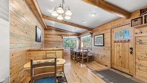A wooden cabin interior with a dining area, a bench, and a door with a window. - 279 Shorewood Dr Grand Lake cabin getaway 3 bedroom, private HT, close to town (Grand Lake)