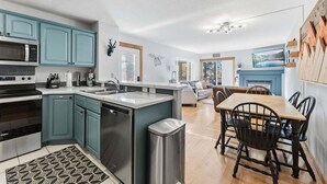 Una cocina moderna con armarios color turquesa, electrodomésticos de acero inoxidable y una isla central.