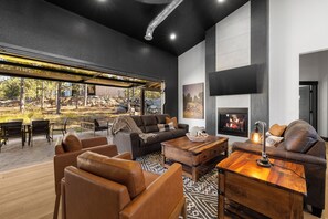 Uma sala de estar moderna com sofás de couro, uma mesa de centro de madeira e uma lareira.