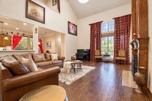A spacious living room with a leather sofa, a coffee table, and a television.