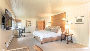 A bedroom with a bed, bedside tables, a desk, and a chair. - The Steakhouse (Crested Butte)