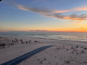 A beach with a clear path leading to the water, surrounded by sand and sparse vegetation. - Welcome to Sea Shed – Private Pool, Fire Pit, Pet Friendly (Cape San Blas)