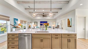 A spacious kitchen with a large island, wooden cabinets, and a dishwasher. - Lulu's Beach House- Volleyball Court, North Cape (Port St Joe)