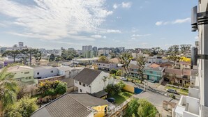 Un quartier résidentiel composé de différents types de bâtiments, notamment des maisons et des immeubles d’appartements, sous un ciel dégagé parsemé de quelques nuages.