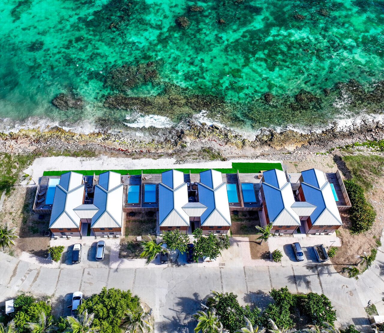 An aerial view of a resort with multiple buildings, each with a blue roof and a central courtyard.