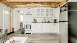 A modern kitchen with white cabinets, a stainless steel refrigerator, and a wooden ceiling. - Elegant home away from home - Valley View (Brooklyn)