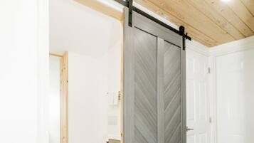 A room with a sliding barn door, a toilet, and a sink.