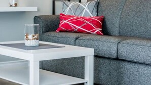 A modern living room with a grey sofa, a white coffee table, and a floor lamp.