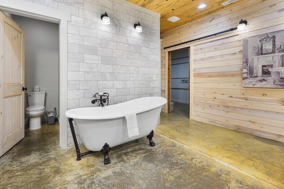 Une salle de bain avec une baignoire sur pieds, des toilettes et un lavabo.