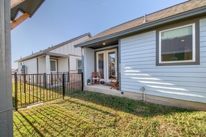 A row of single-story houses with a front porch and a small garden area. - Ot 2125 Creekside Cottage 2 Bedroom Home (New Braunfels)