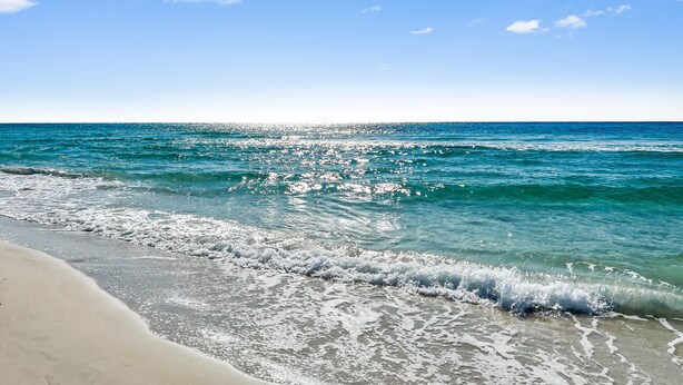 A beach with clear blue water and a sandy shore. - Blue Palm 3 Bedroom Home (Panama City Beach)