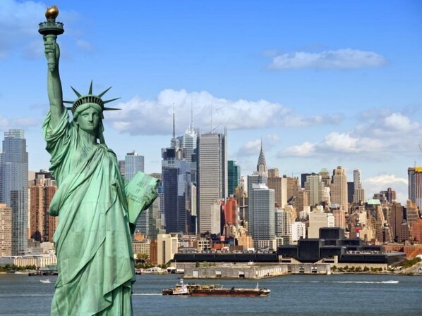 The Statue of Liberty with a city skyline in the background.