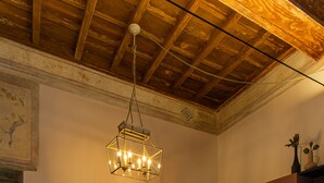 A dining area with a checkered floor, a wooden ceiling, and a hanging light fixture. - La Voliera di Bacco - House with panoramic terrace in the heart of Frascati (Frascati)