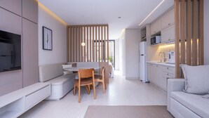 A modern kitchen with white cabinets, a microwave, and a coffee machine. - Solena Hotel (São Sebastião)