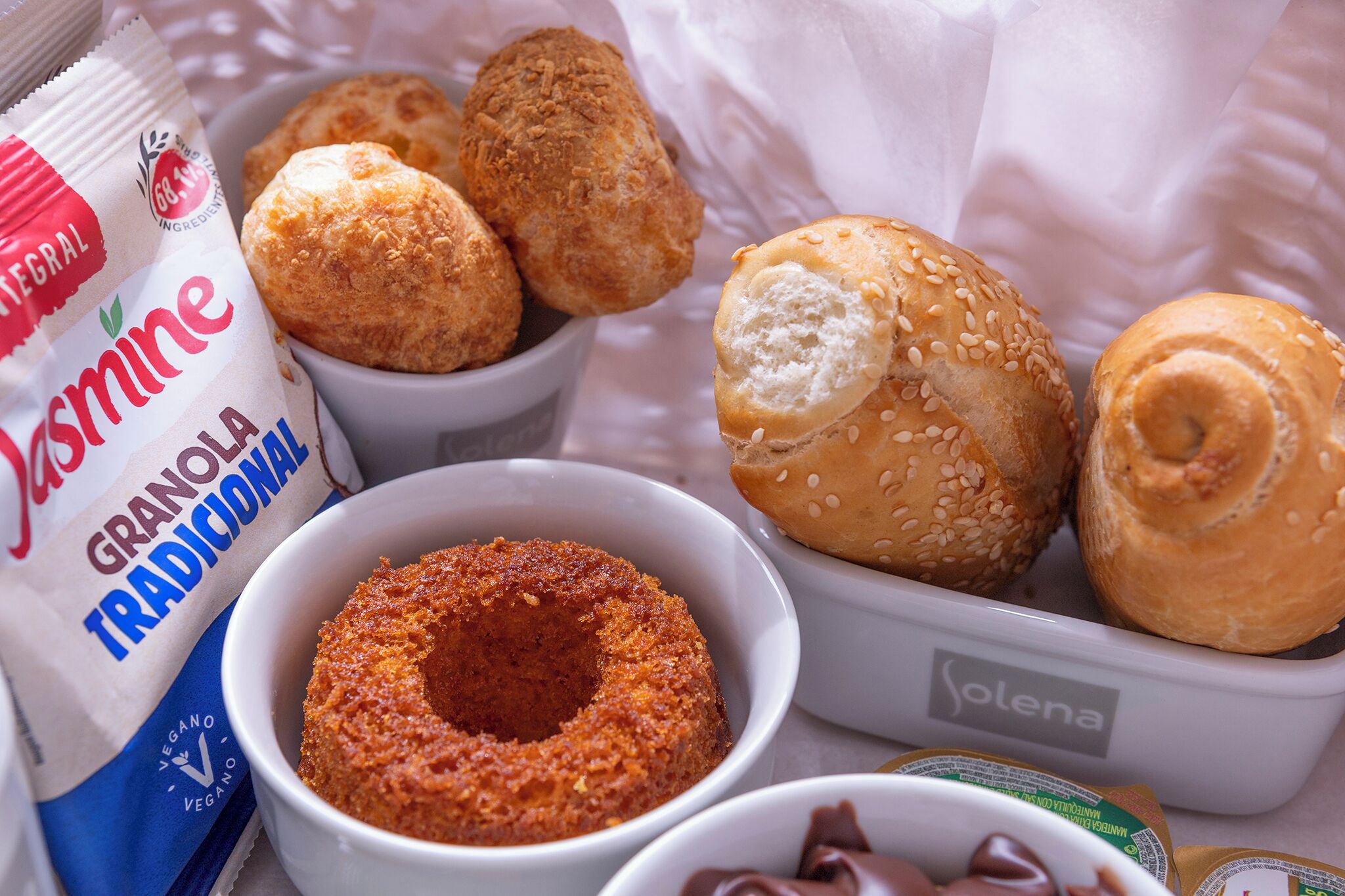 Una selezione di prodotti da forno, tra cui pasticcini e una ciotola di granola.