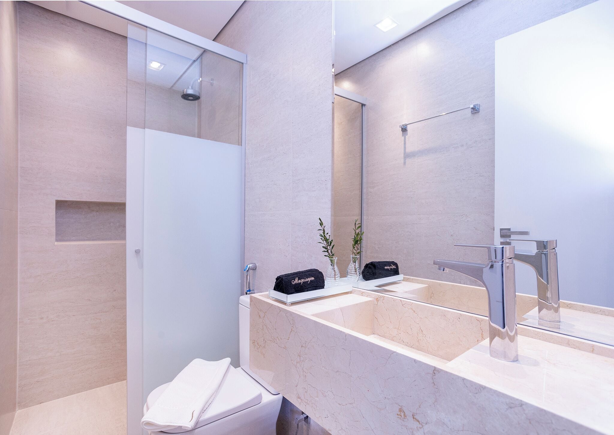 Un baño moderno con un espejo grande, dos lavamanos y una zona de ducha.