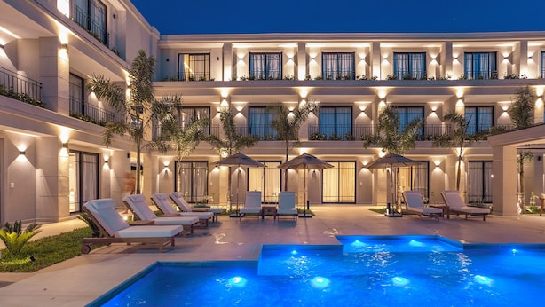 A hotel courtyard with a swimming pool, sun loungers, and umbrellas. - Solena Hotel (São Sebastião)