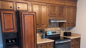 A kitchen with wooden cabinets, a stainless steel oven, and a built-in microwave.
