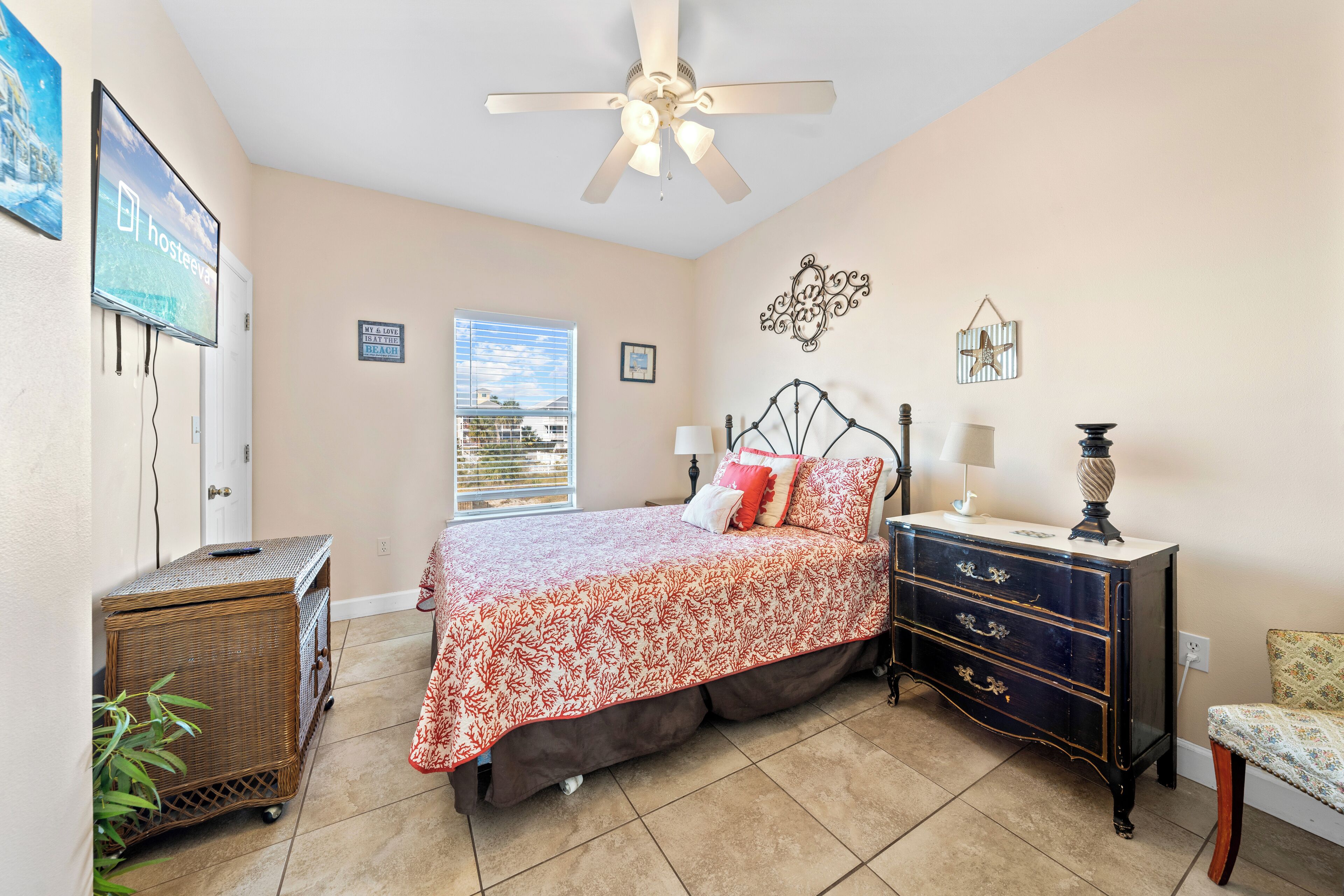 A bedroom with a bed, dresser, ceiling fan, and a window with blinds.