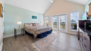 A bedroom with a bed, a nightstand, a dresser, and a ceiling fan. - Sea Watch Unit A (Gulf Shores)