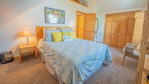 A bedroom with a bed, a nightstand, a lamp, a fan, and wooden wardrobes. - Townhome in Crested Butte | 3 Bedroom | Walk to Elk Ave | Gas Grill | Parking (Crested Butte)