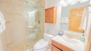 A bathroom with a glass-enclosed shower, a white toilet, a wooden cabinet, a sink with a mirror, and a towel rack. - Townhome in Crested Butte | 3 Bedroom | Walk to Elk Ave | Gas Grill | Parking (Crested Butte)