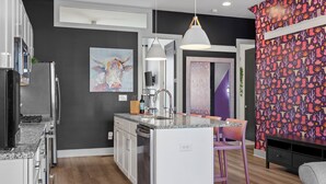 A modern kitchen with a central island, stainless steel appliances, and a pendant light. - NEW! Sleeps 20+ 2 SideBySide East Nashville Homes! (Nashville)