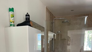 Ein modernes Badezimmer mit Dusche, Waschbecken und Spiegel.