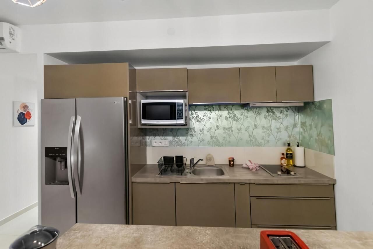 Eine kleine Küche mit Kühlschrank, Mikrowelle und Spüle.